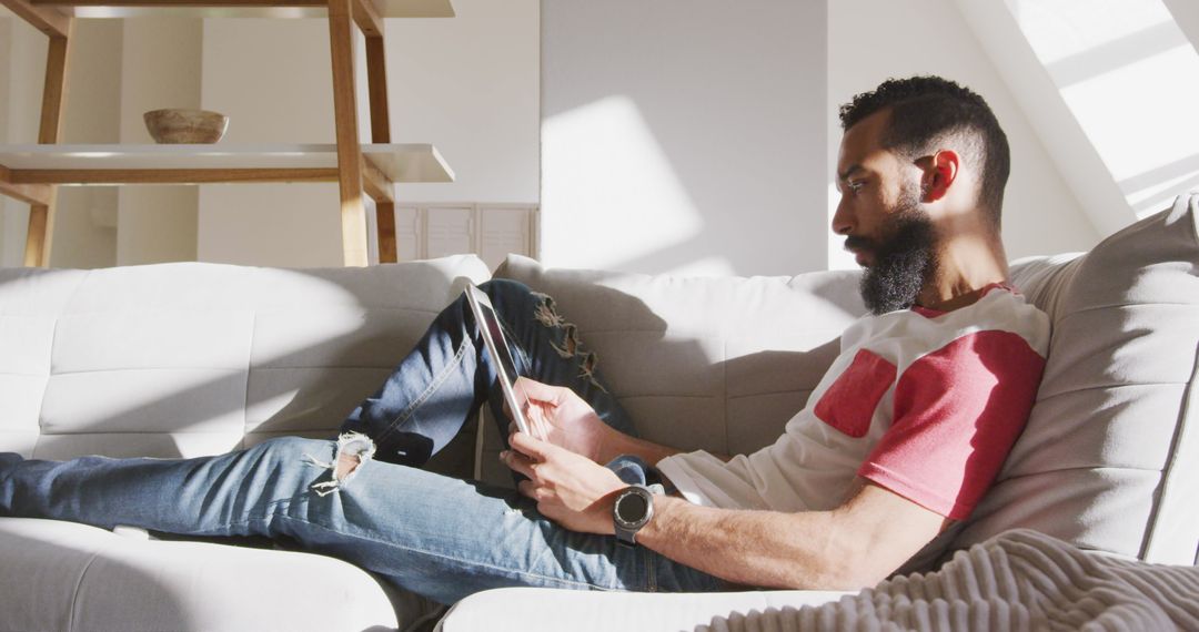 Man Relaxing on Sofa at Weekend Using Tablet