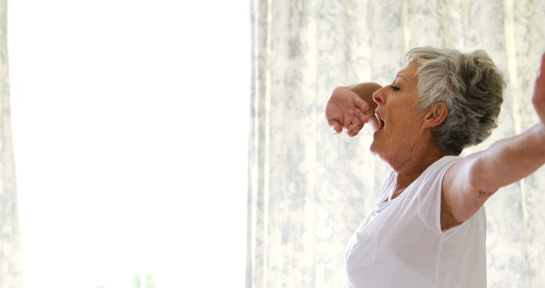 Senior Woman Stretching and Yawning in Morning Light - Free Images, Stock Photos and Pictures on Pikwizard.com