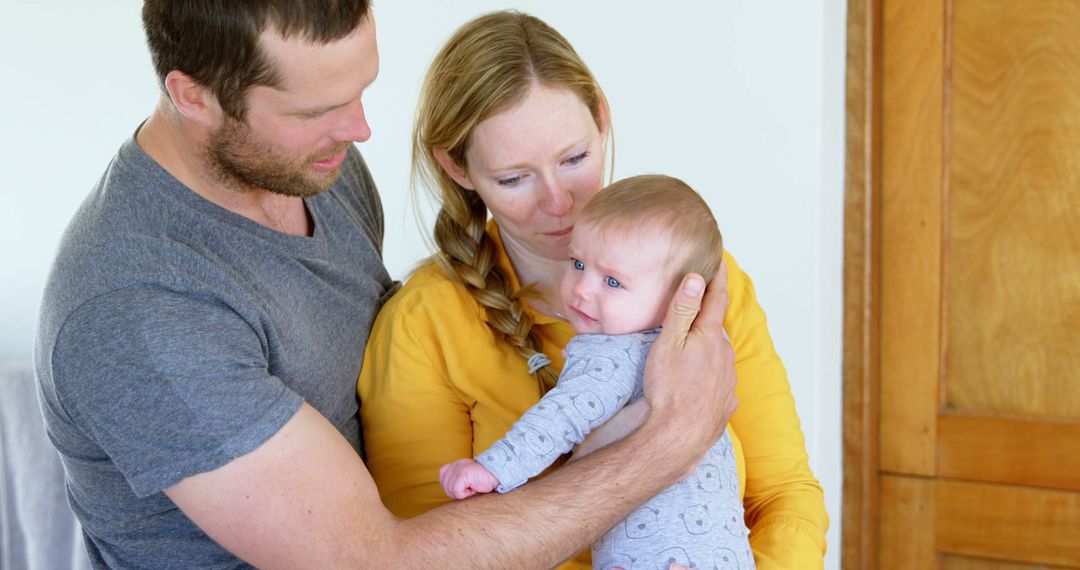 Caucasian Parents Embracing Newborn at Home