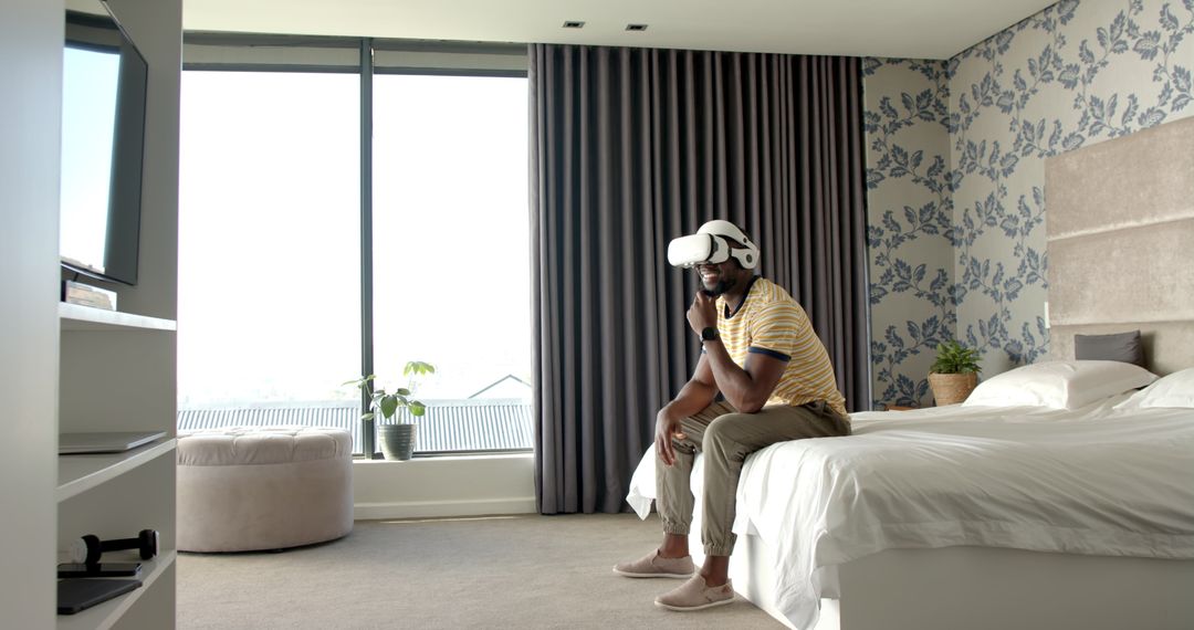 Man Sitting on Bed Enjoying Virtual Reality in Modern Bedroom