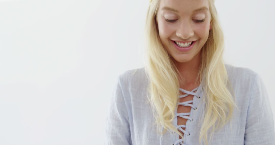 Smiling Blonde Woman in Light Blue Blouse Looking Down - Free Images, Stock Photos and Pictures on Pikwizard.com