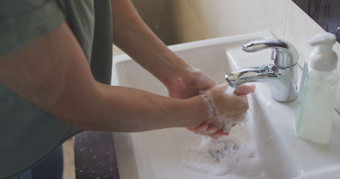 Person Washing Hands with Soap under Running Tap in Bathroom - Free Images, Stock Photos and Pictures on Pikwizard.com