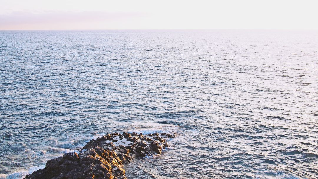 Sunset Over Tranquil Ocean with Rocky Shoreline - Free Images, Stock Photos and Pictures on Pikwizard.com