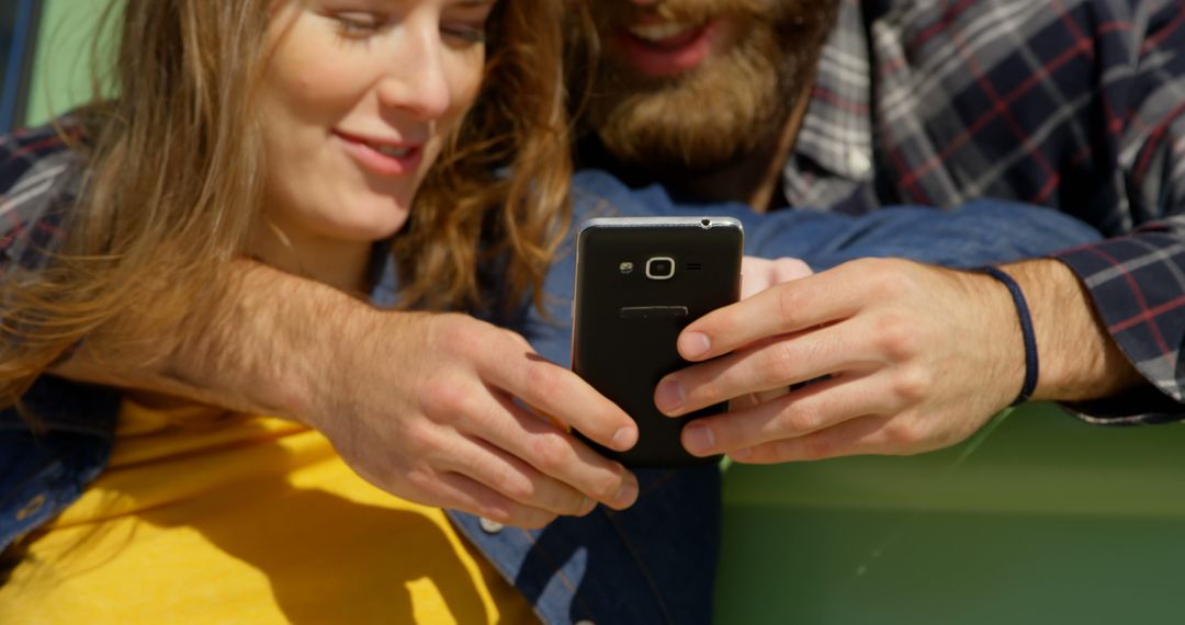Young Couple Joyfully Sharing Content on Mobile Device