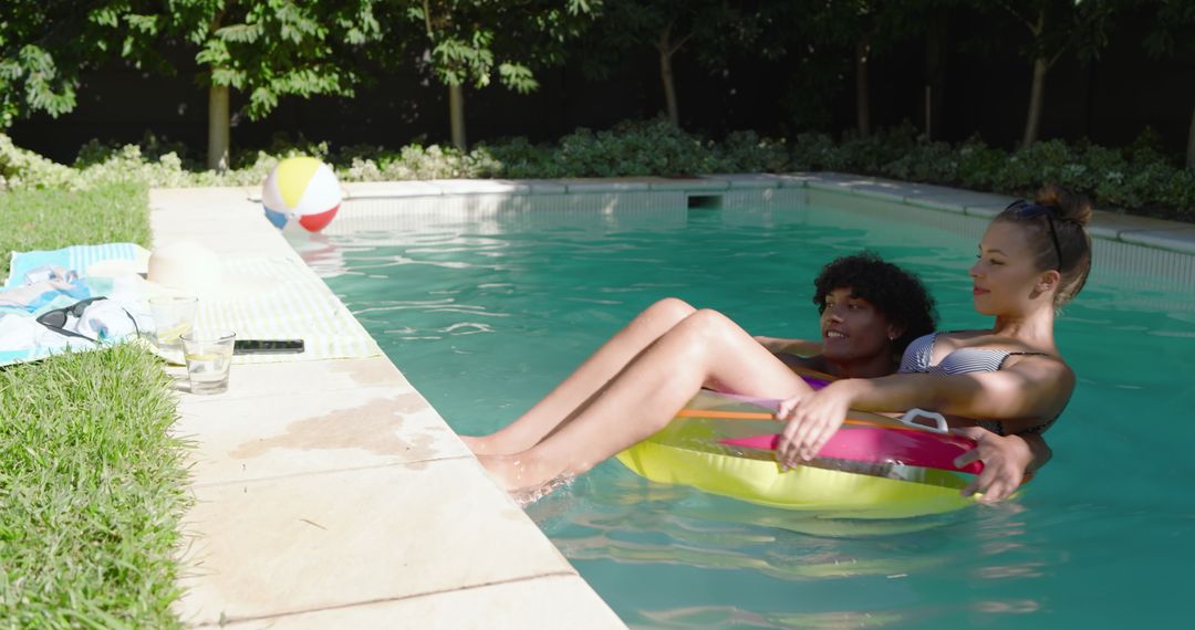 Diverse Couple Relaxing on Inflatable Pool Ring in Backyard Oasis