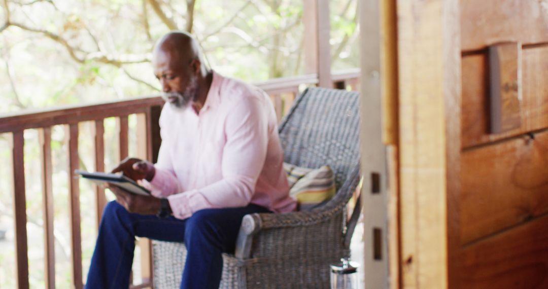 Senior african american man on balcony in log cabin using tablet - Free Images, Stock Photos and Pictures on Pikwizard.com