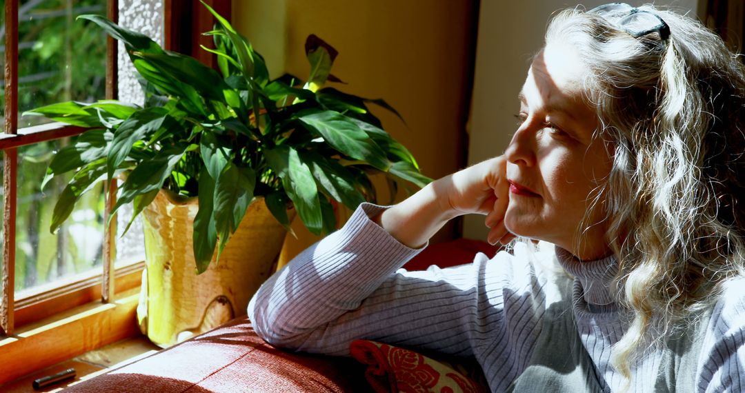 Peaceful Woman Relaxing by Window on Sunny Day - Free Images, Stock Photos and Pictures on Pikwizard.com