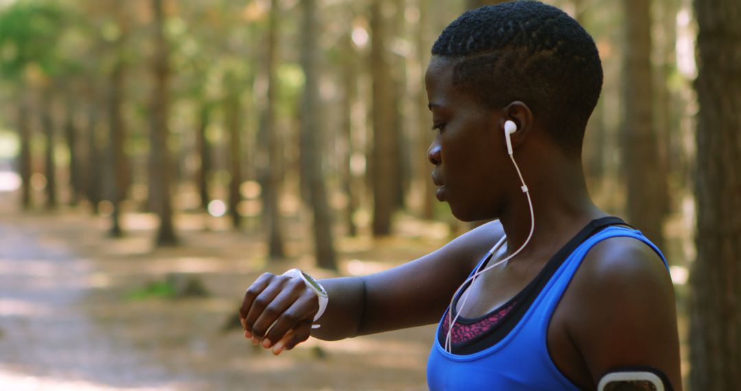 Female Running Jogger Tracking Time with Smartwatch in Forest - Free Images, Stock Photos and Pictures on Pikwizard.com