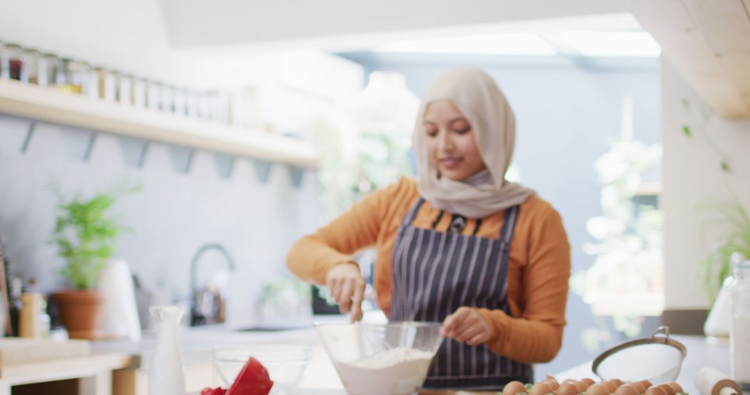 Smiling woman in hijab preparing dough in modern kitchen - Free Images, Stock Photos and Pictures on Pikwizard.com