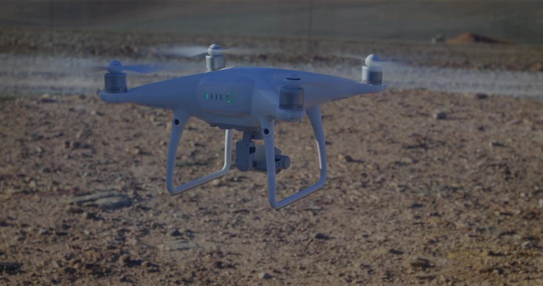 White Quadcopter Drone Hovering Over Rocky Desert Field With Camera Gimbal, Cinematic