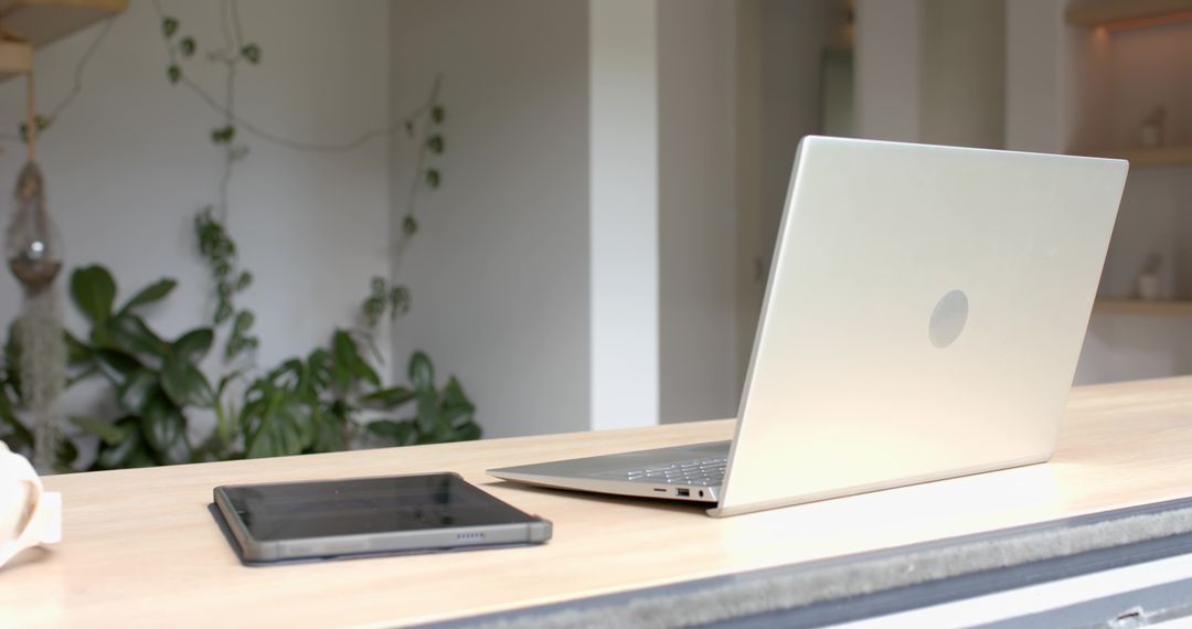 Minimalist Workspace with Silver Laptop and Tablet on Sleek Wooden Desk