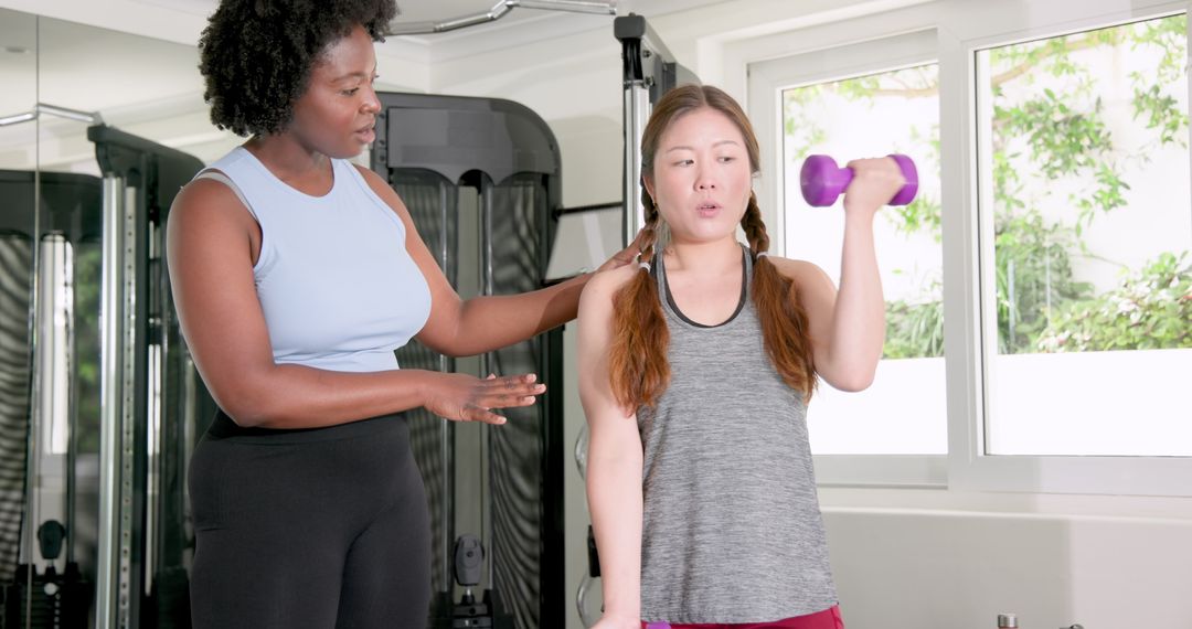 Fitness Trainer Coaching Client On Dumbbell Workout Routine