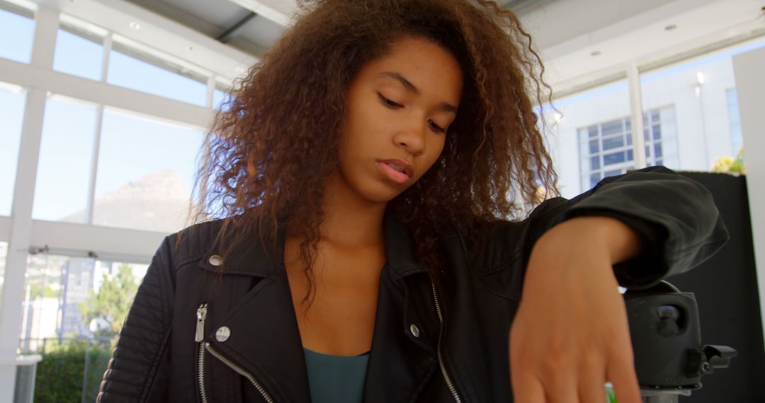 Pensive Young Woman with Curly Hair in Leather Jacket - Free Images, Stock Photos and Pictures on Pikwizard.com