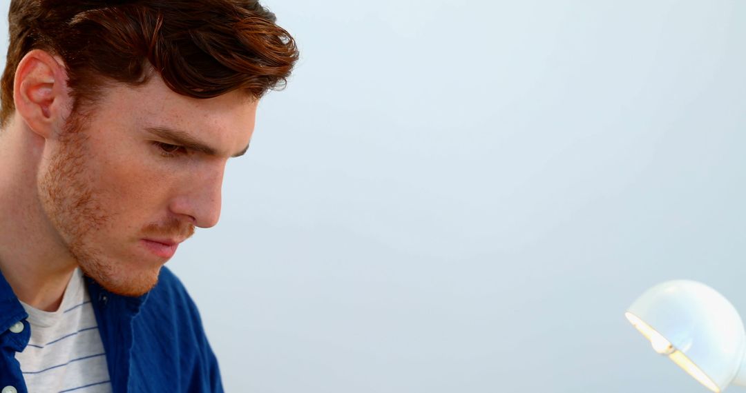 Focused Man Sitting by Desk with Thoughtful Expression and Copy Space