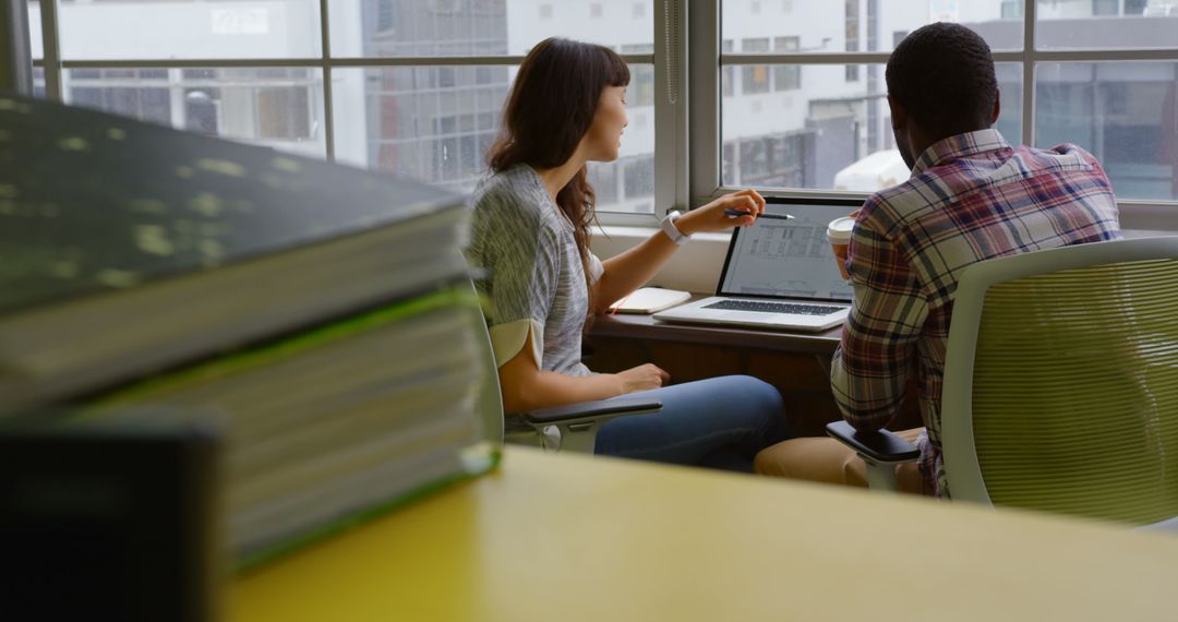 Diverse Business Team Collaborates Over Laptop in Modern Office