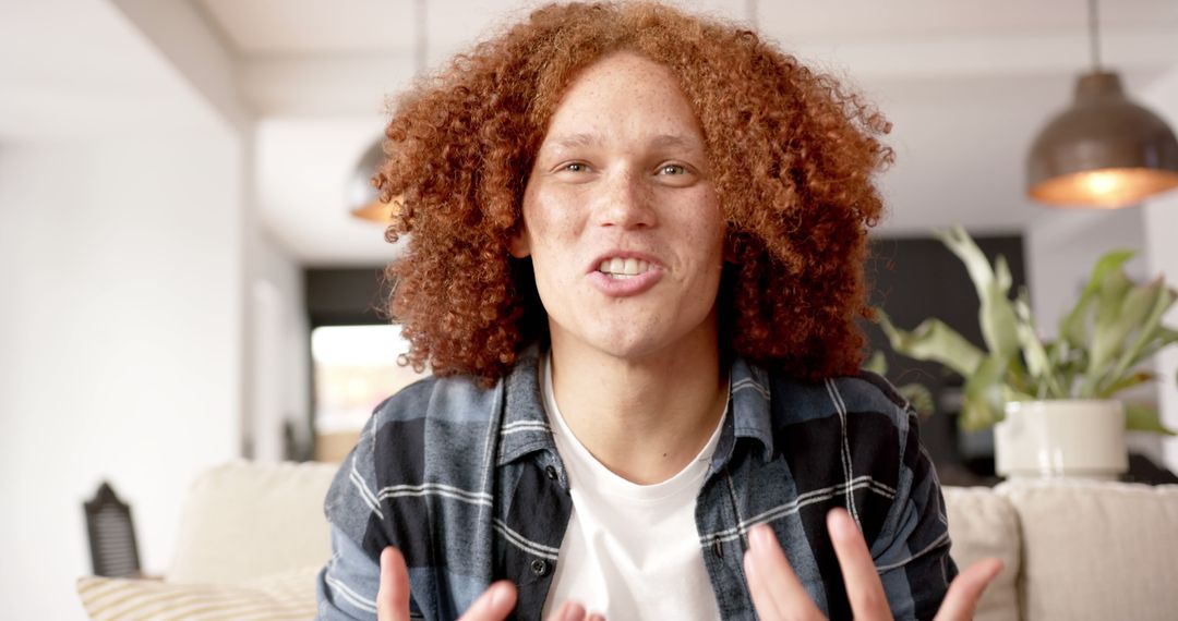 Young Man with Curly Hair Sharing Exciting News from Home - Free Images, Stock Photos and Pictures on Pikwizard.com