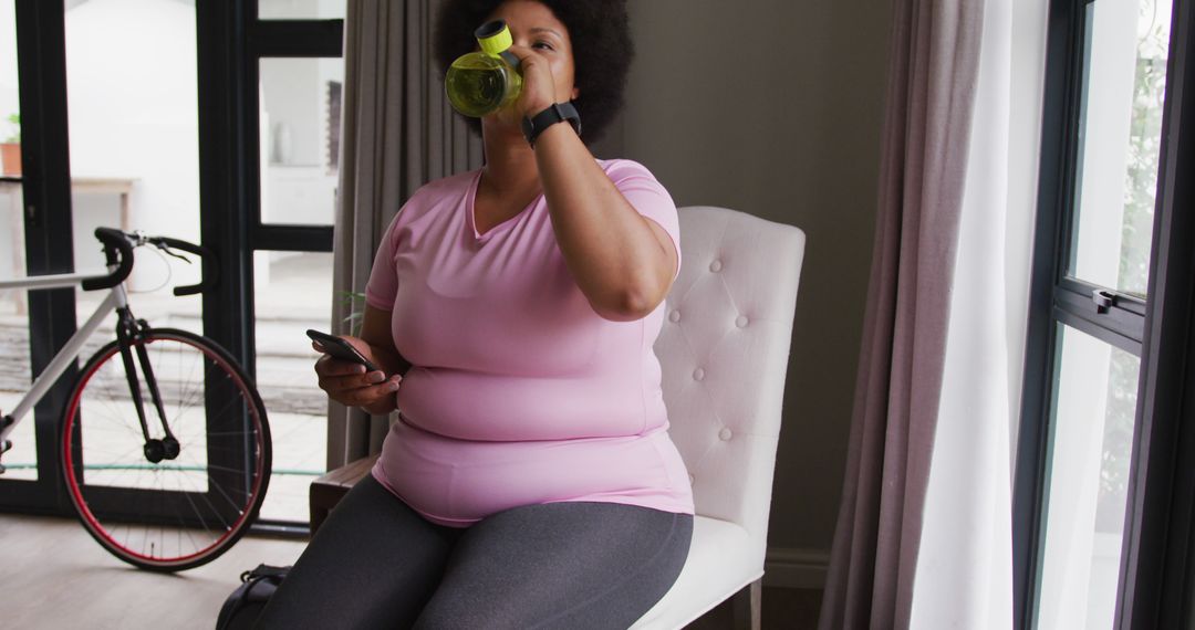 Image of plus size african american woman in sport clothes drinking water - Free Images, Stock Photos and Pictures on Pikwizard.com