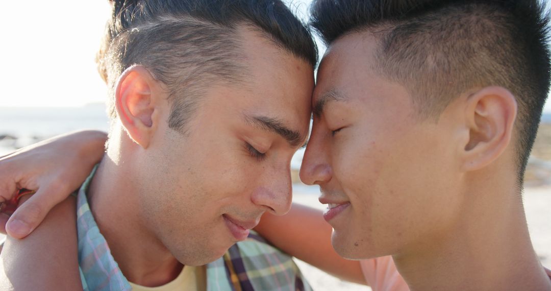 Happy diverse gay male couple embracing by the sea - Free Images, Stock Photos and Pictures on Pikwizard.com