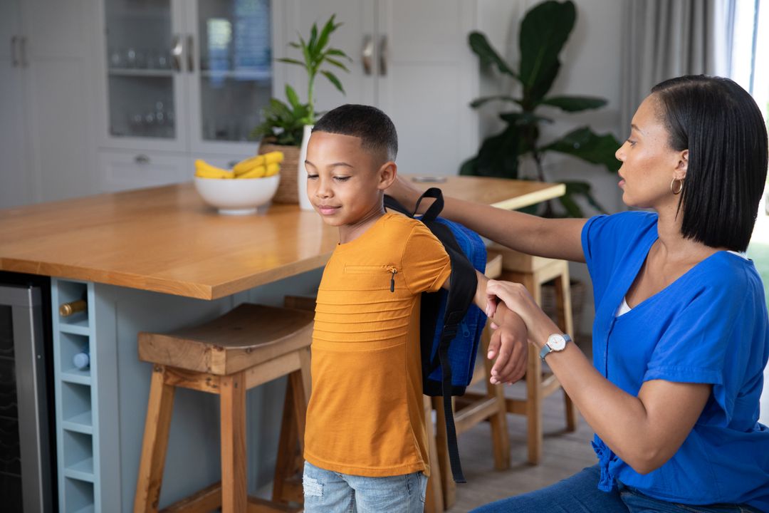 Mother Assisting Son with Backpack for School at Home