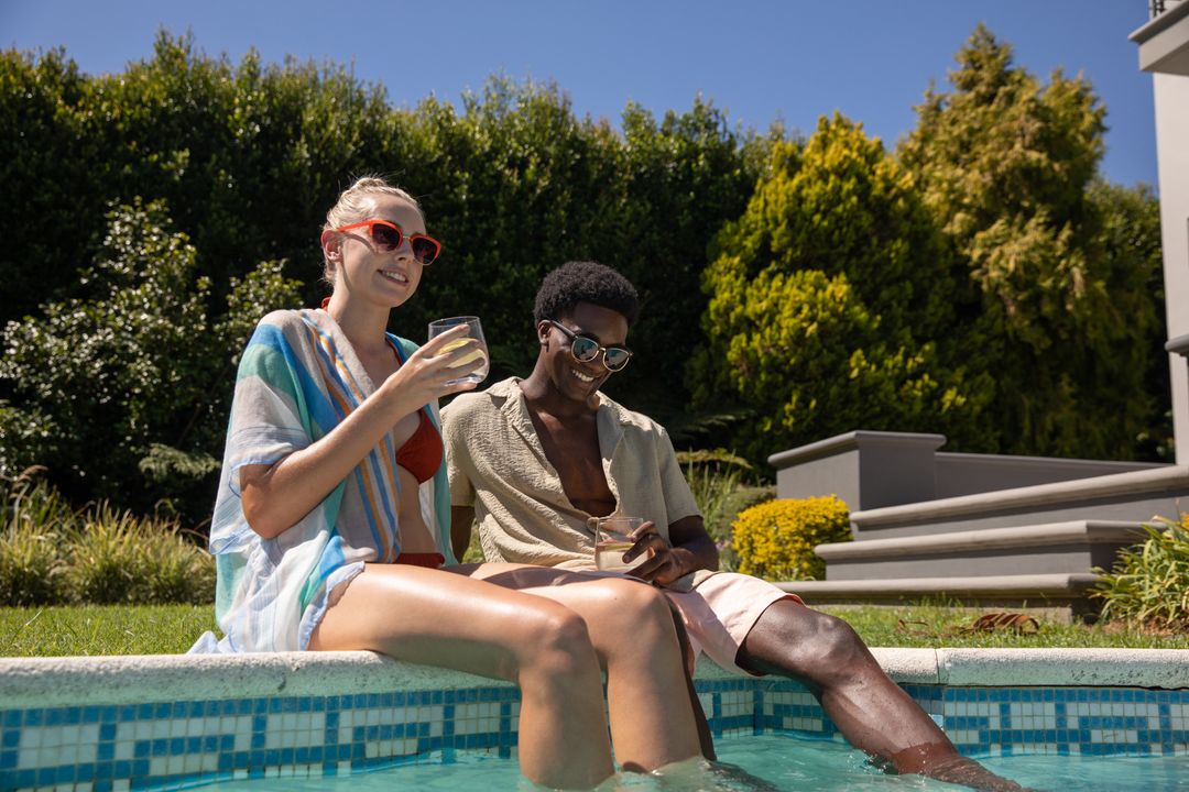 Diverse Couple Relaxing Poolside Under Sungear