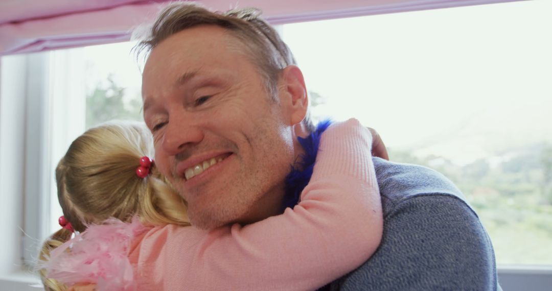 Father hugging daughter inside bright room - Free Images, Stock Photos and Pictures on Pikwizard.com