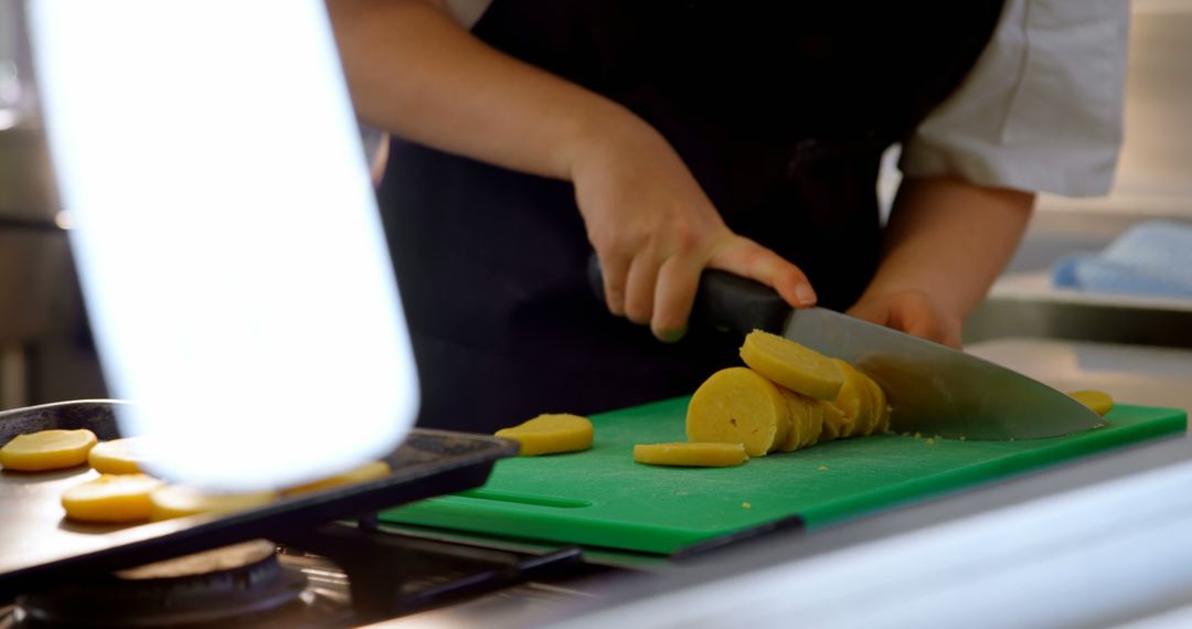 Chef slicing potato on green cutting board in kitchen close-up - Free Images, Stock Photos and Pictures on Pikwizard.com