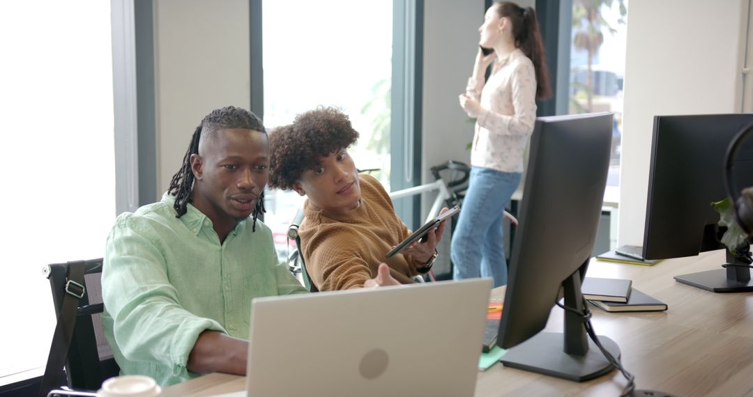 Coworkers Engaging in Teamwork in Modern Office Environment
