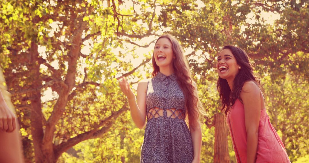 Young Women Laughing in Sunny Park - Free Images, Stock Photos and Pictures on Pikwizard.com