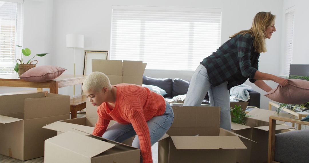 Young Women Unpacking Boxes in New Home - Free Images, Stock Photos and Pictures on Pikwizard.com