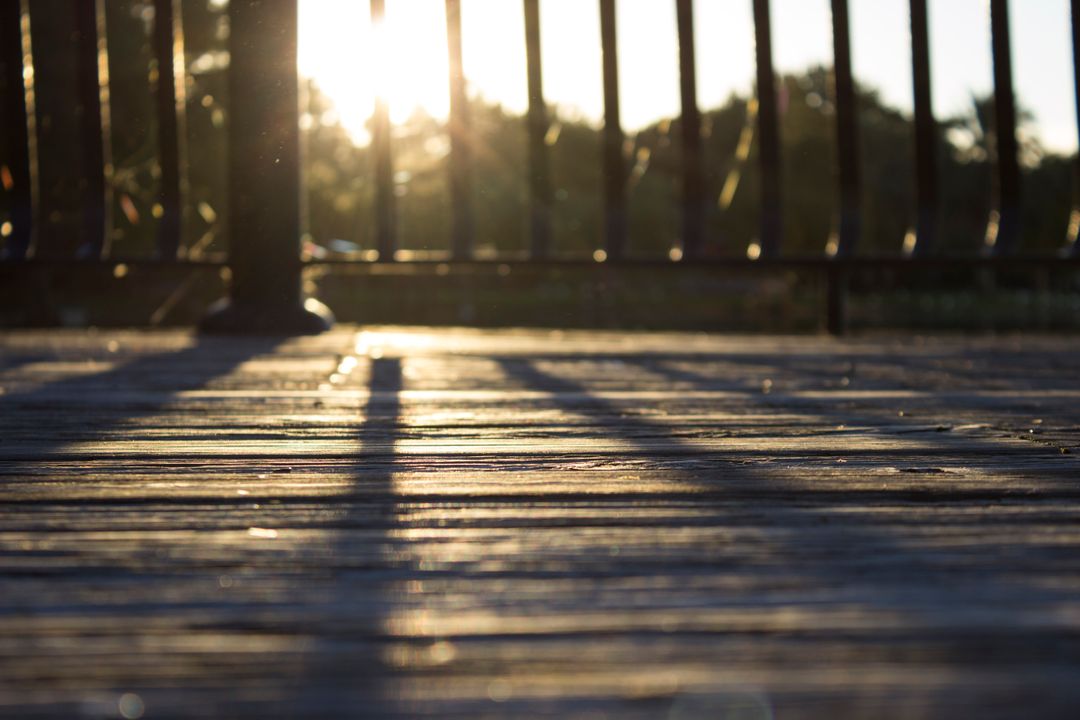 Sunset casting long shadows on wooden deck - Free Images, Stock Photos and Pictures on Pikwizard.com