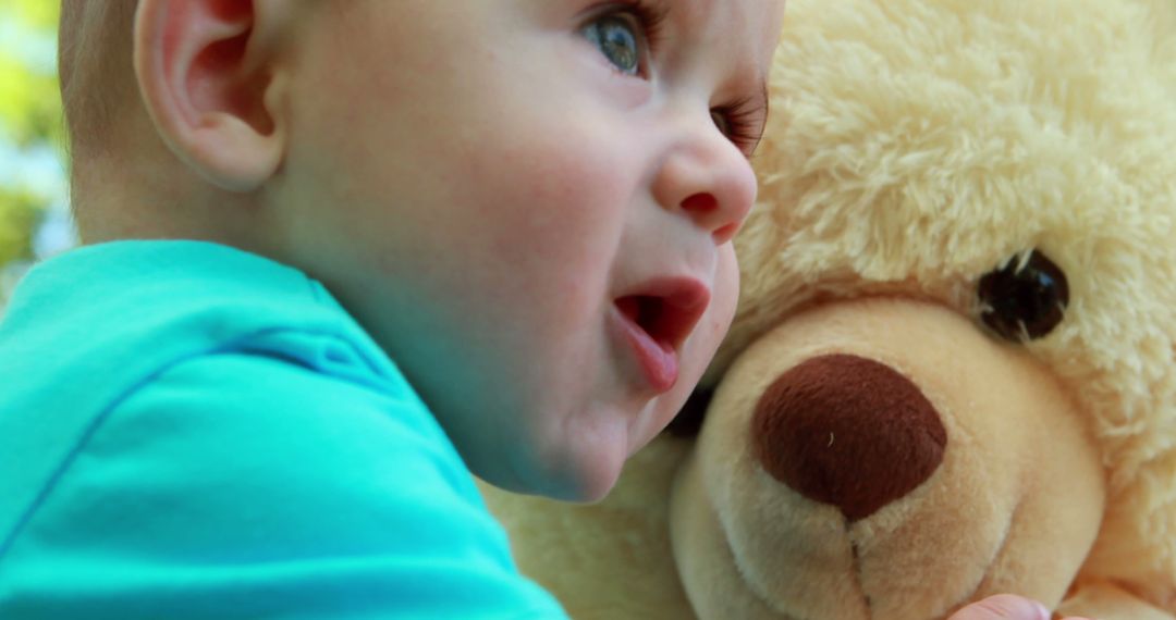 Baby hugging teddy bear with affection and curiosity - Free Images, Stock Photos and Pictures on Pikwizard.com