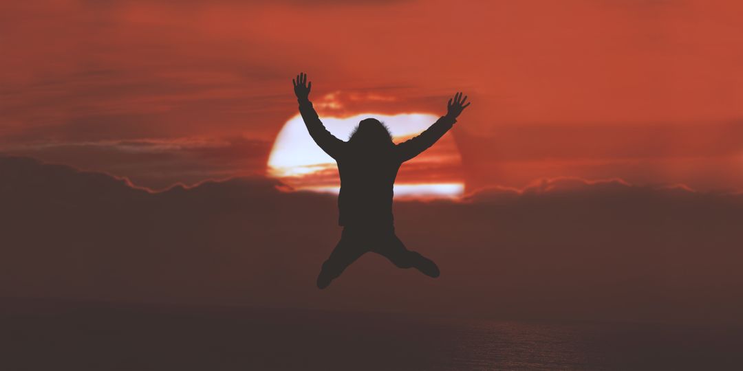 Person Jumping Silhouette Against Vibrant Sunset Sky - Free Images, Stock Photos and Pictures on Pikwizard.com