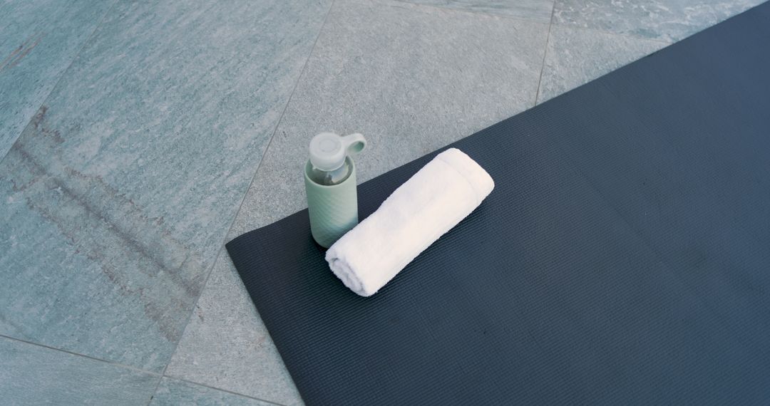 Minimalist Yoga Mat with Towel and Hydro Flask on Stone Floor