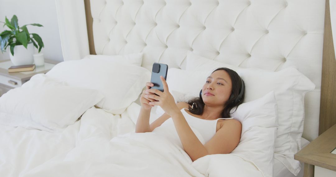 Woman Relaxing in Bed Using Smartphone in Bright Bedroom - Free Images, Stock Photos and Pictures on Pikwizard.com