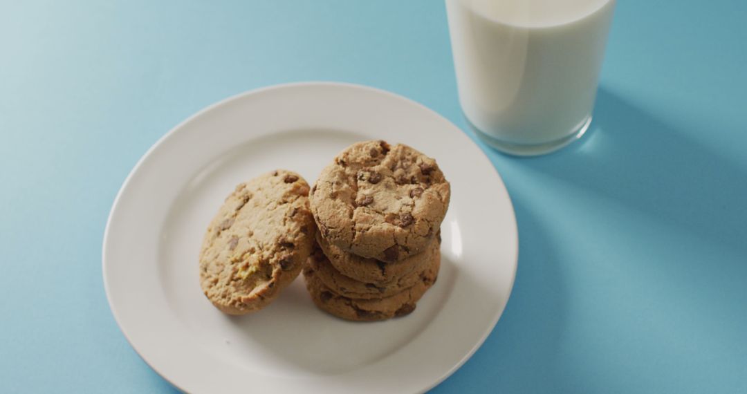 Delicious Chocolate Chip Cookies with Glass of Milk on Blue Background - Free Images, Stock Photos and Pictures on Pikwizard.com