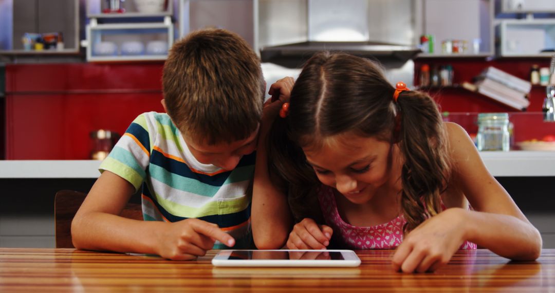 Children Using Tablet Together in Modern Kitchen - Free Images, Stock Photos and Pictures on Pikwizard.com