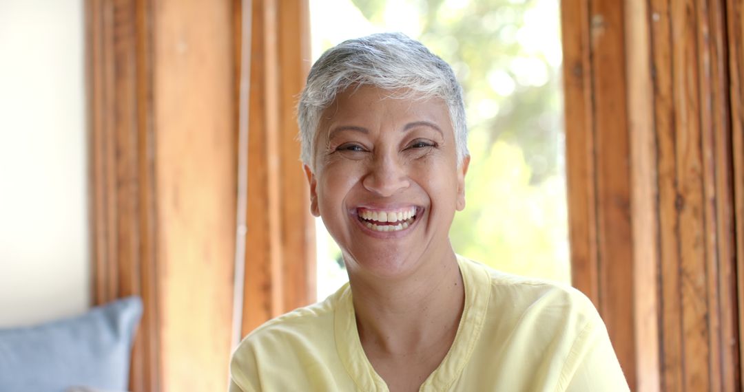 Smiling Senior Woman Relaxing at Home by Window