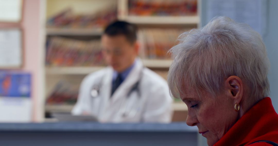 Senior Woman Waiting in Doctor's Office with Medical Professional in Background - Free Images, Stock Photos and Pictures on Pikwizard.com