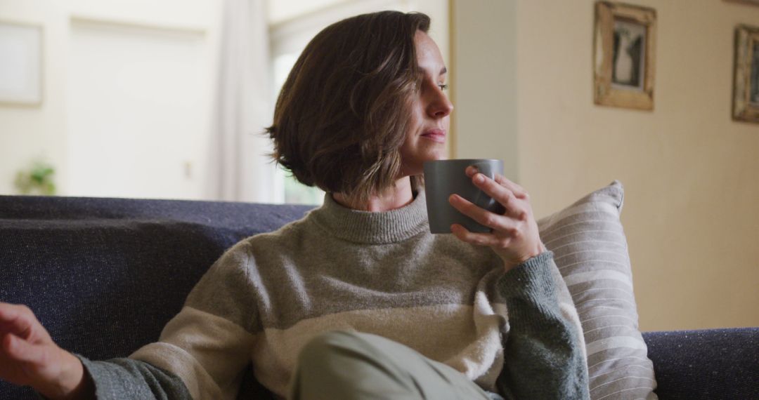 Woman Relaxing on Couch Enjoying Hot Beverage - Free Images, Stock Photos and Pictures on Pikwizard.com