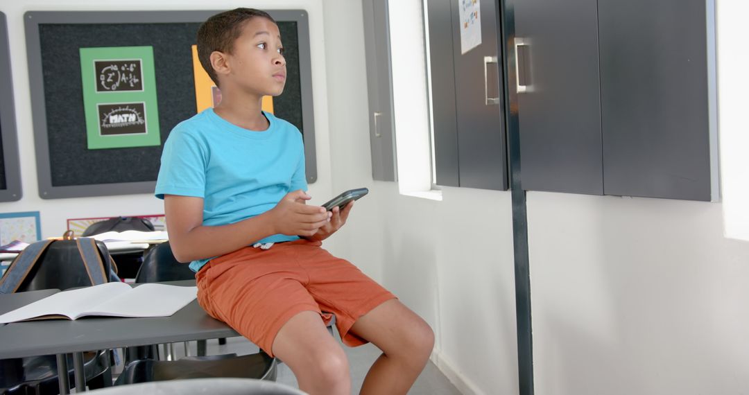 Student Holding Smartphone in Classroom Learning Environment