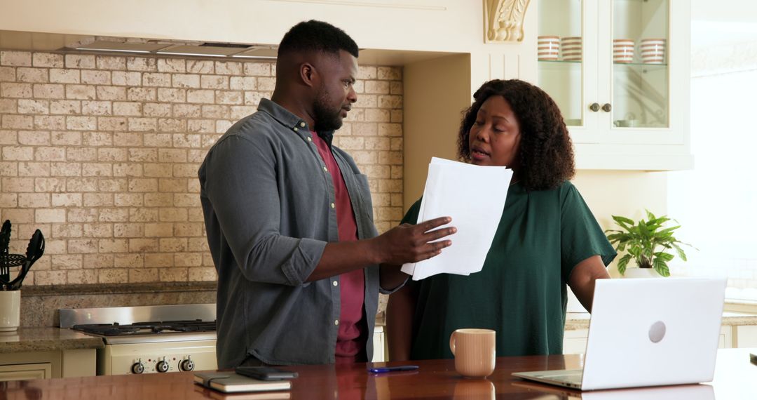 Mature Couple Discussing Documents in Stylish Kitchen