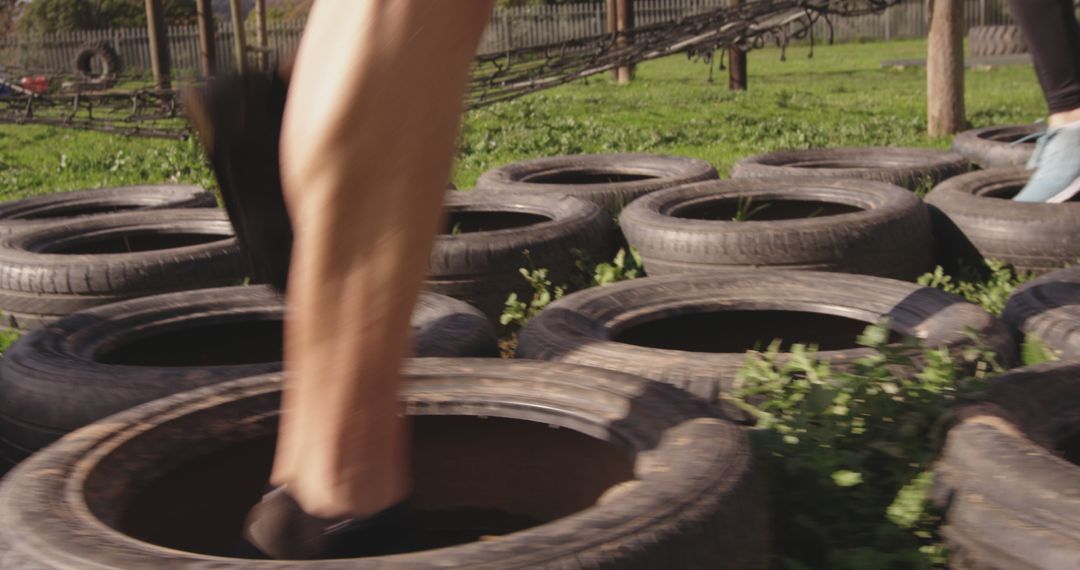 Athlete's legs running through tire agility course on grass - Free Images, Stock Photos and Pictures on Pikwizard.com