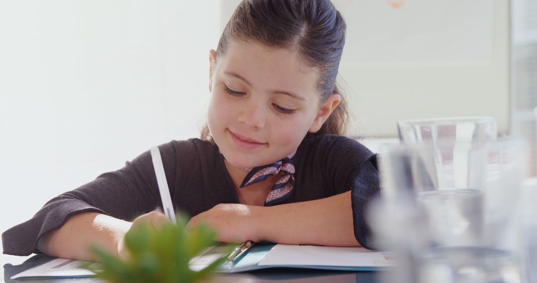 Young Girl Studying Diligently with Notebook and Pen