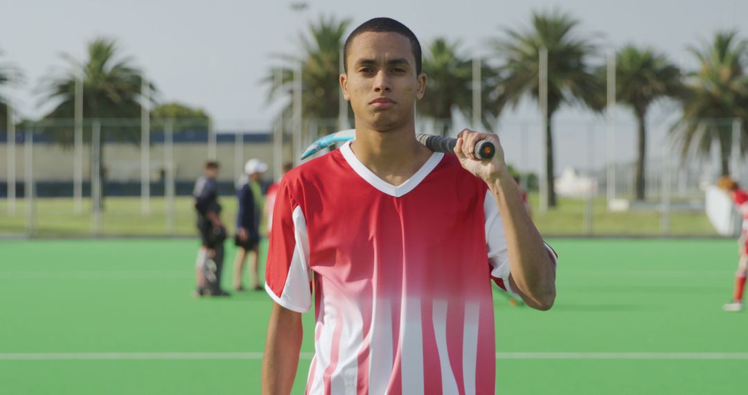 Confident Field Hockey Player Standing with Stick on Shoulder - Free Images, Stock Photos and Pictures on Pikwizard.com