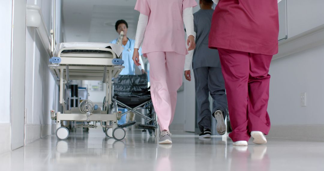 Healthcare Professionals Walking in Hospital Corridor Near Medical Equipment - Free Images, Stock Photos and Pictures on Pikwizard.com