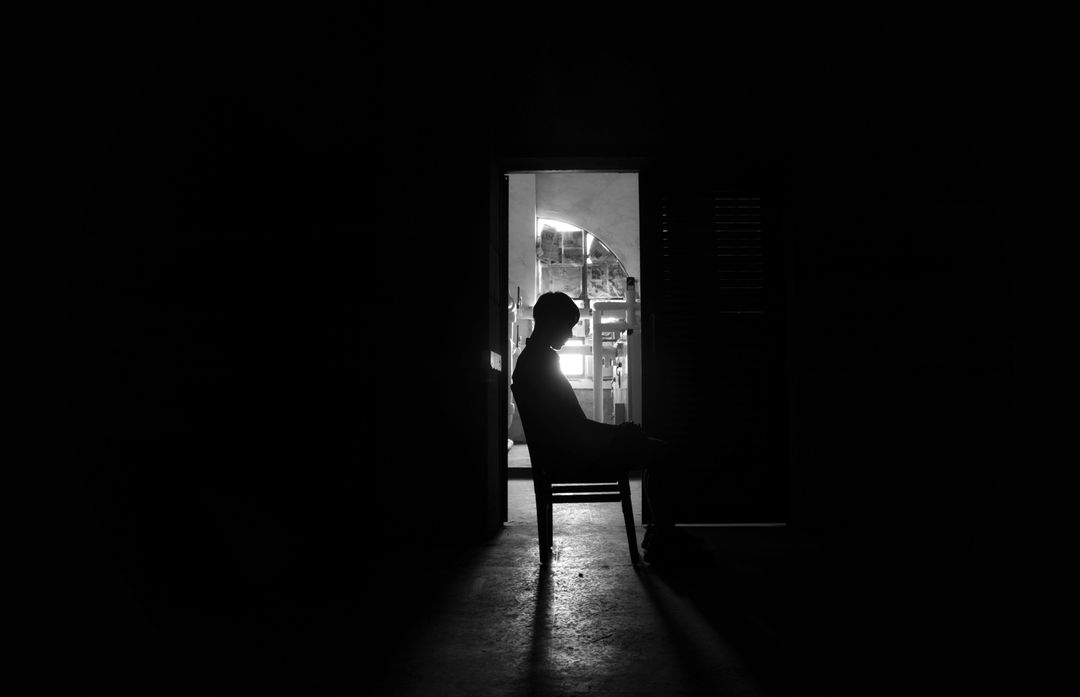 Silhouette of Man Sitting in Dark Room at Doorway - Free Images, Stock Photos and Pictures on Pikwizard.com