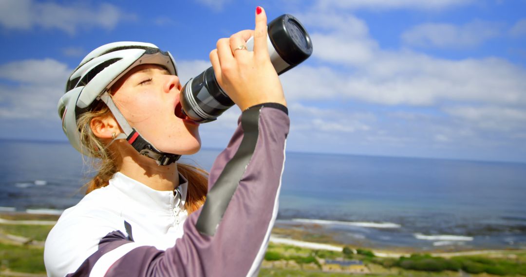 Female Cyclist Drinking Water Backdrop Scenic Coastal View - Free Images, Stock Photos and Pictures on Pikwizard.com