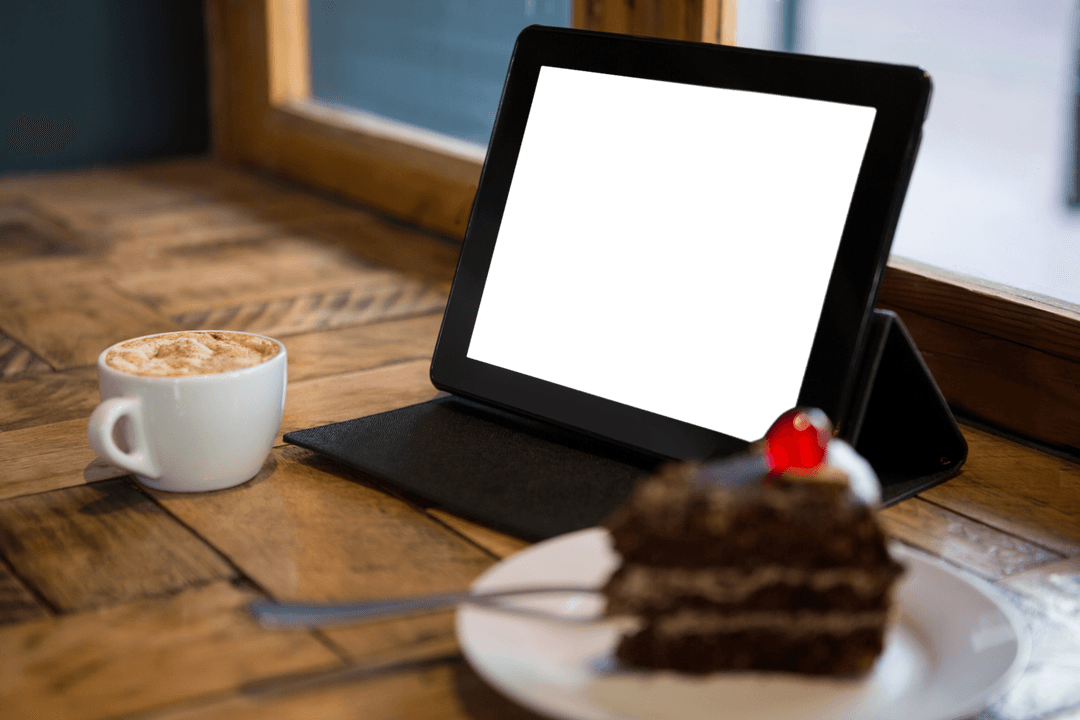 Transparent Tablet Display With Chocolate Cake and Coffee in Cafe