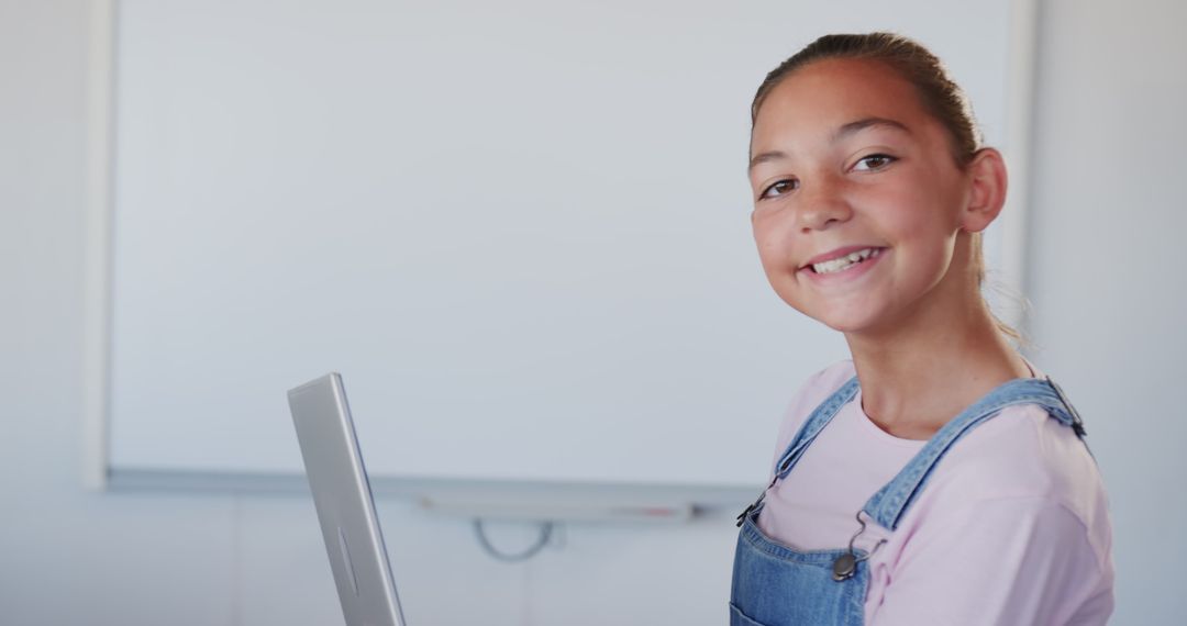 Smiling Girl with Laptop: Embracing Technology in the Classroom