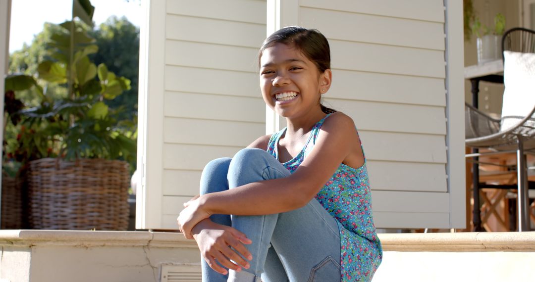 Smiling Girl Relaxing on Sunlit Porch Steps